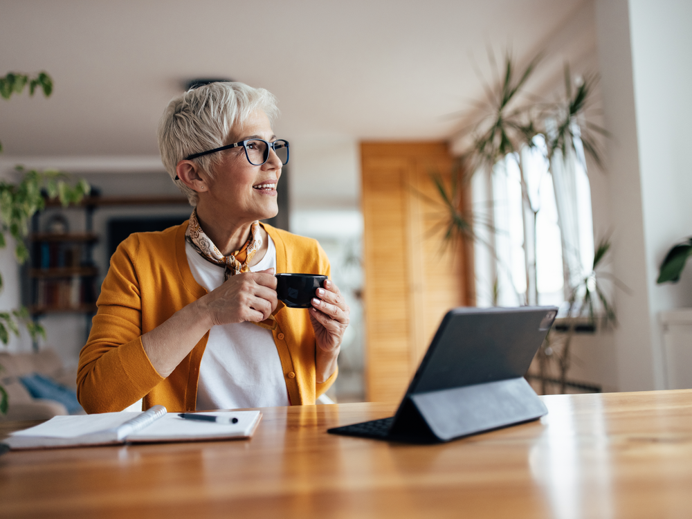 Frau mit Kaffeetasse an einem hellen Arbeitsplatz